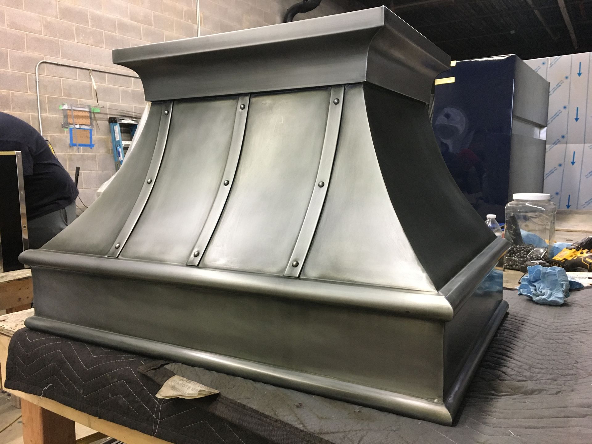 A stainless steel hood is sitting on top of a wooden table.