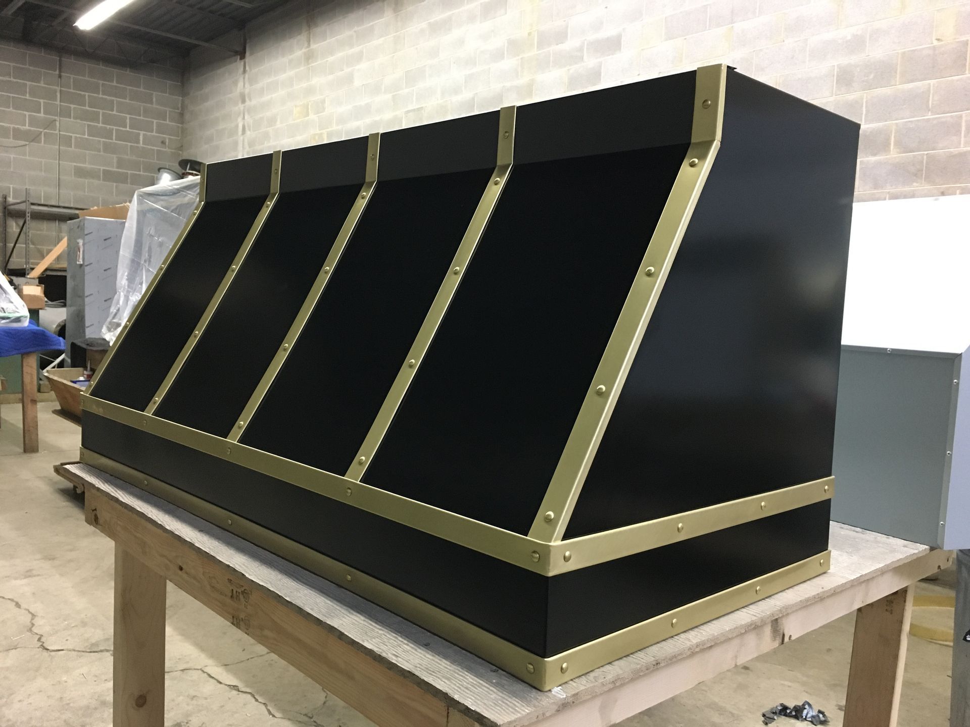 A black box with gold trim is sitting on top of a wooden table.