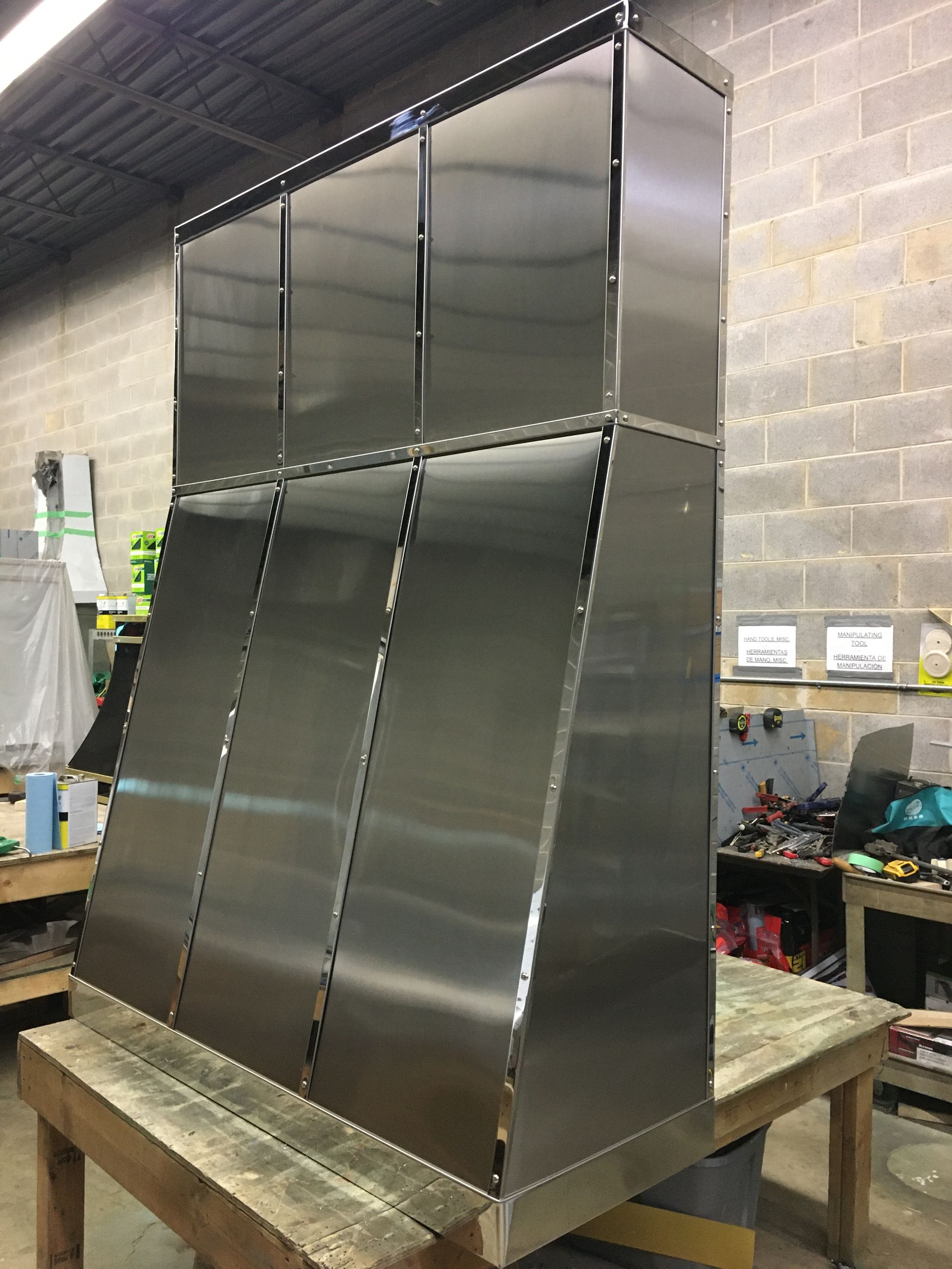 A stainless steel cabinet is sitting on top of a wooden table.