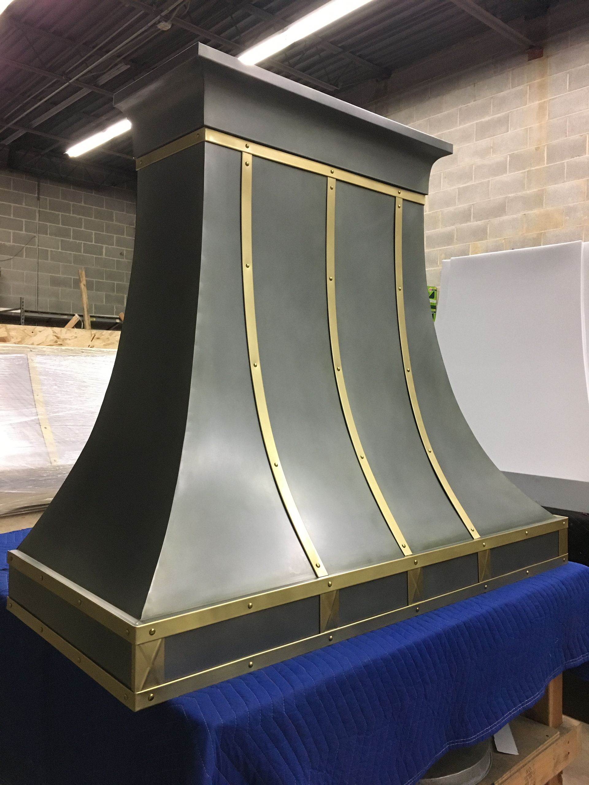 A gray and gold hood is sitting on a blue table cloth.