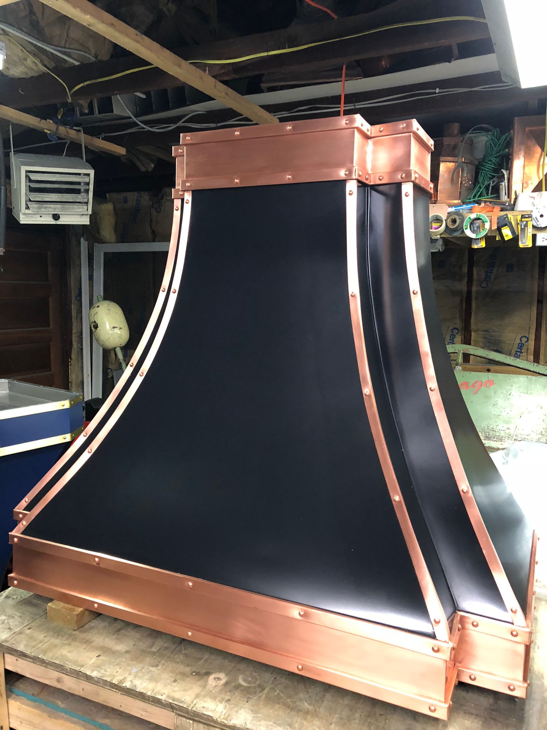 A black and copper hood is sitting on a wooden table.