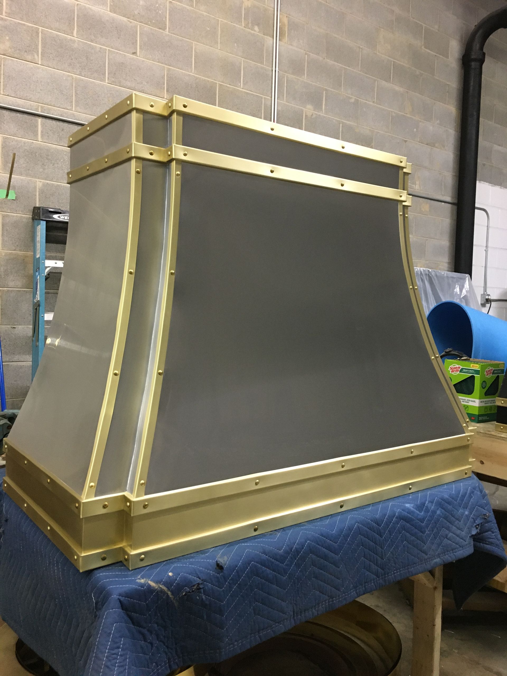 A gray and gold hood is sitting on a table