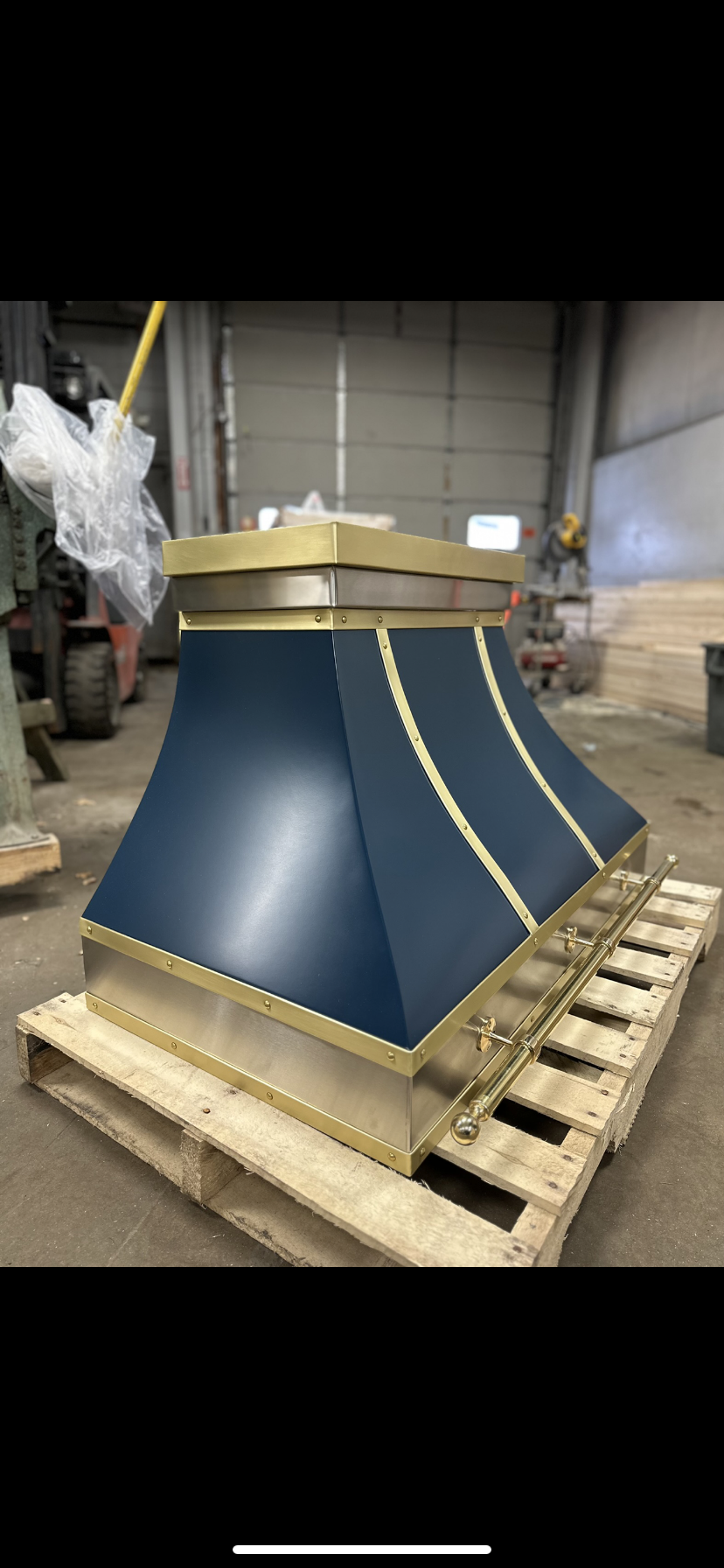 A blue and gold hood is sitting on top of a wooden pallet.