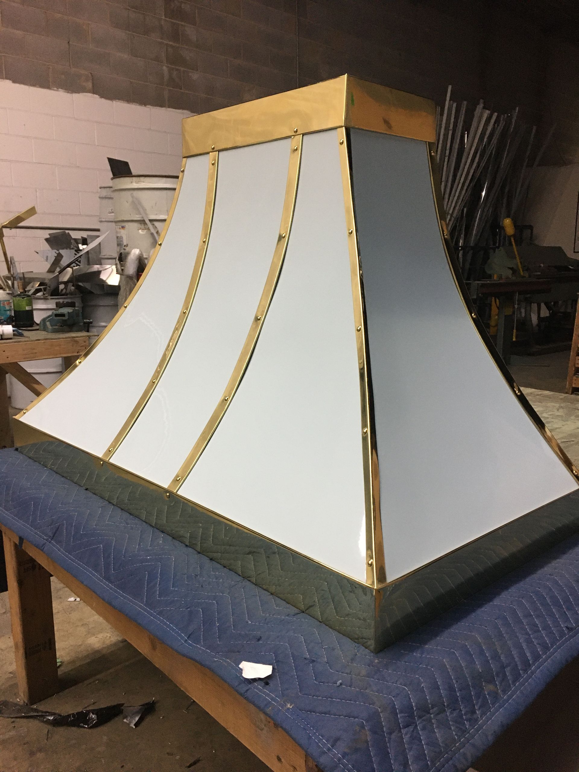 A white and gold lamp shade is sitting on a wooden table.