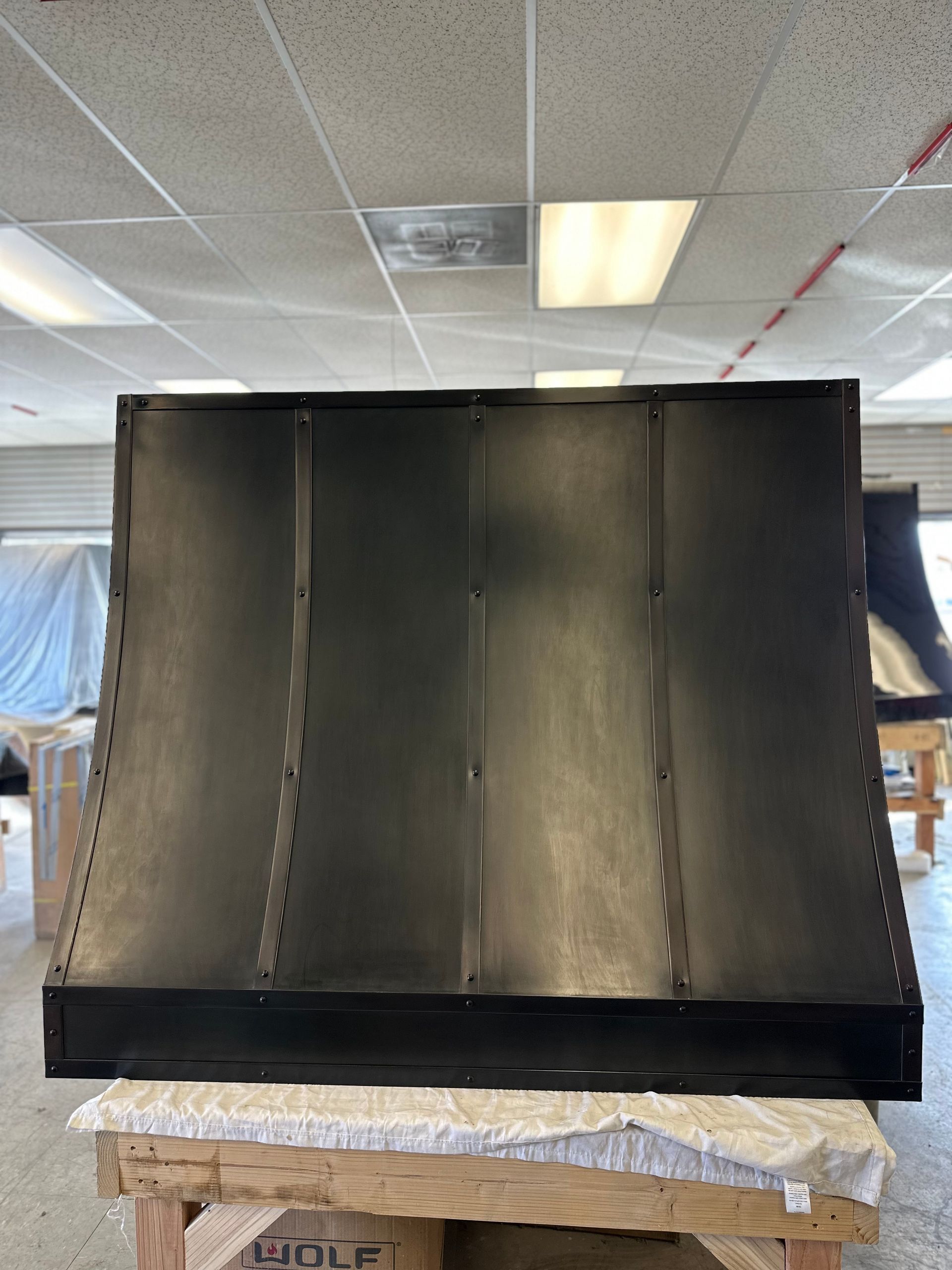 A black hood is sitting on top of a wooden table in a room.