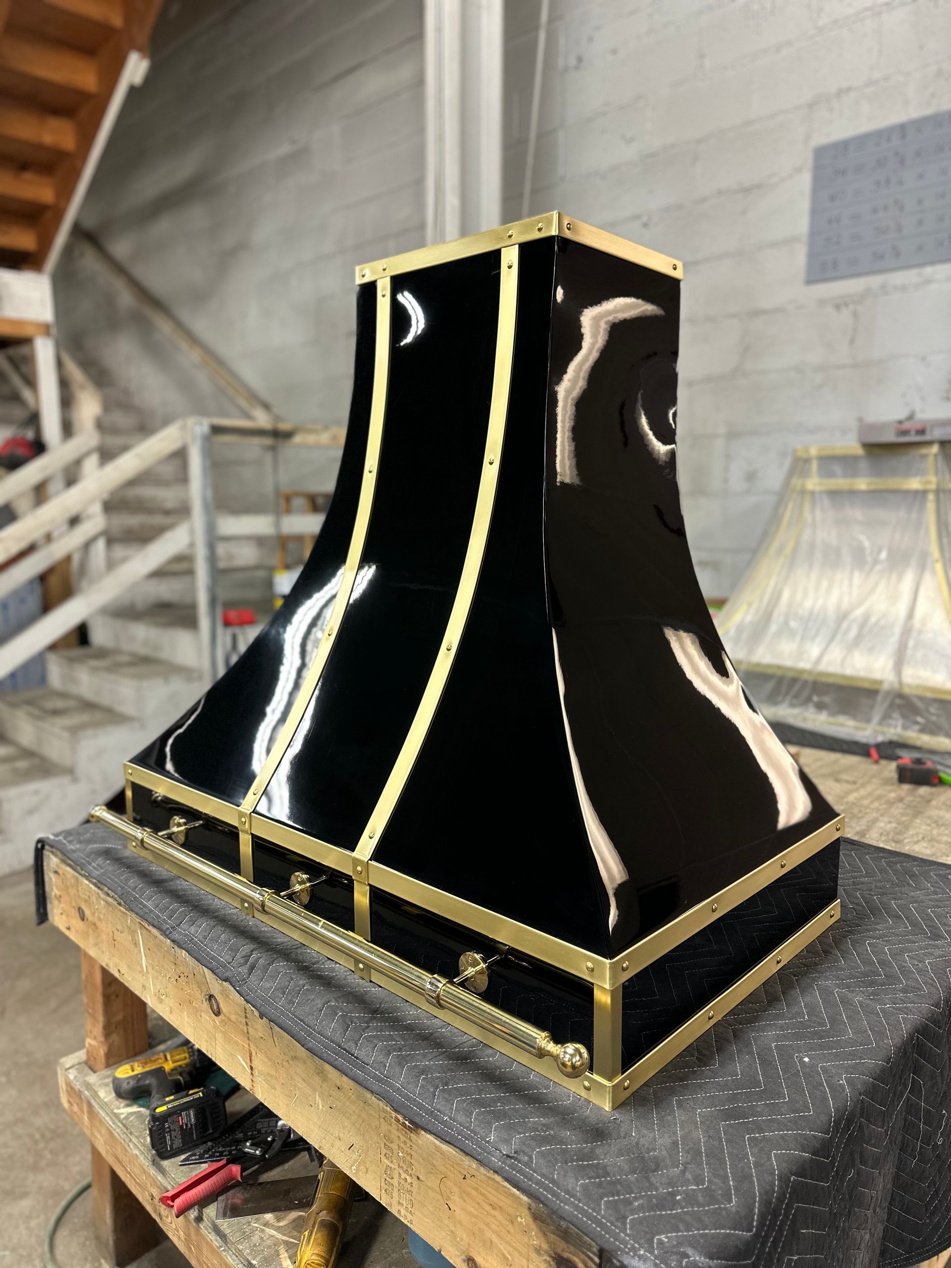 A black and gold hood is sitting on a wooden table.
