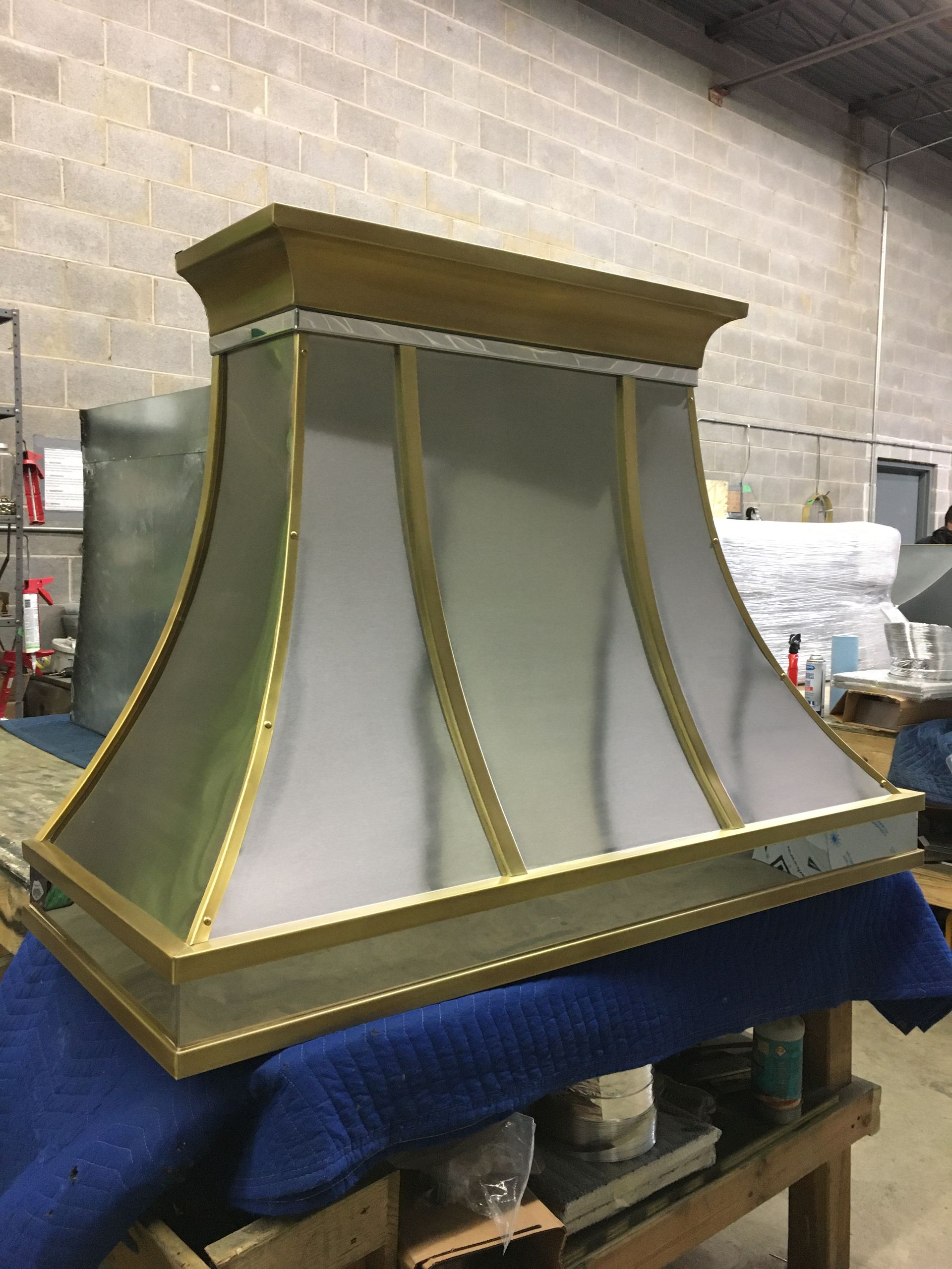 A brass and white hood is sitting on top of a blue table.