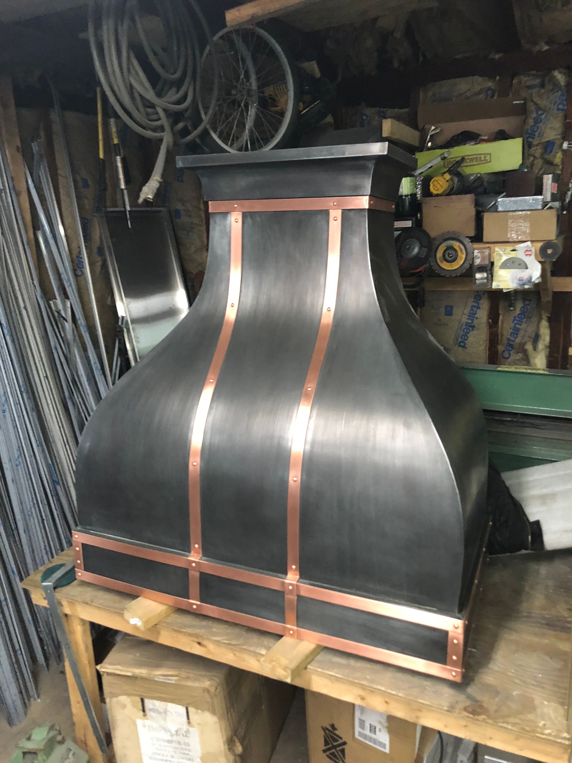 A black and copper hood is sitting on top of a wooden table.