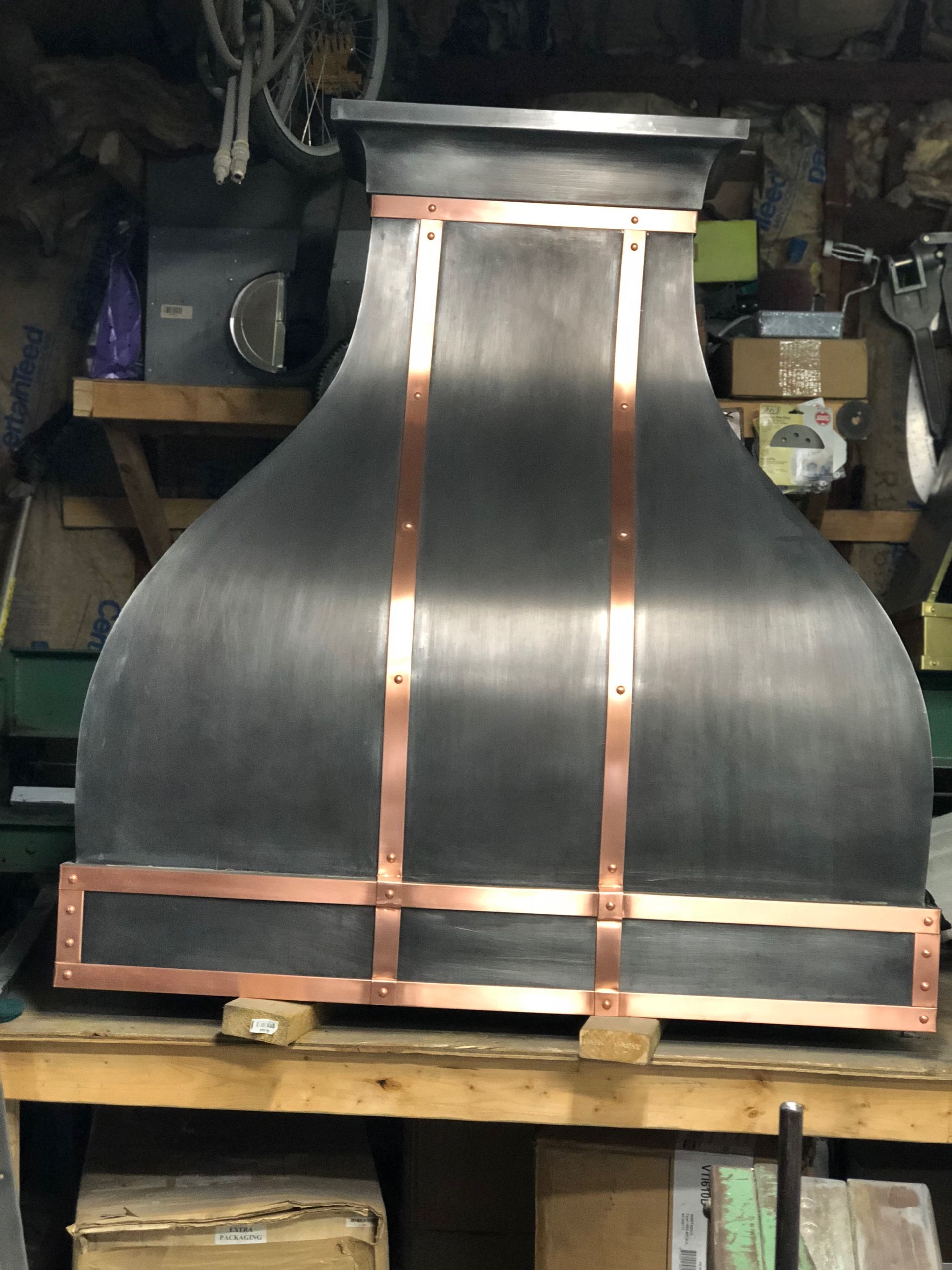 A black and copper hood is sitting on a wooden table.