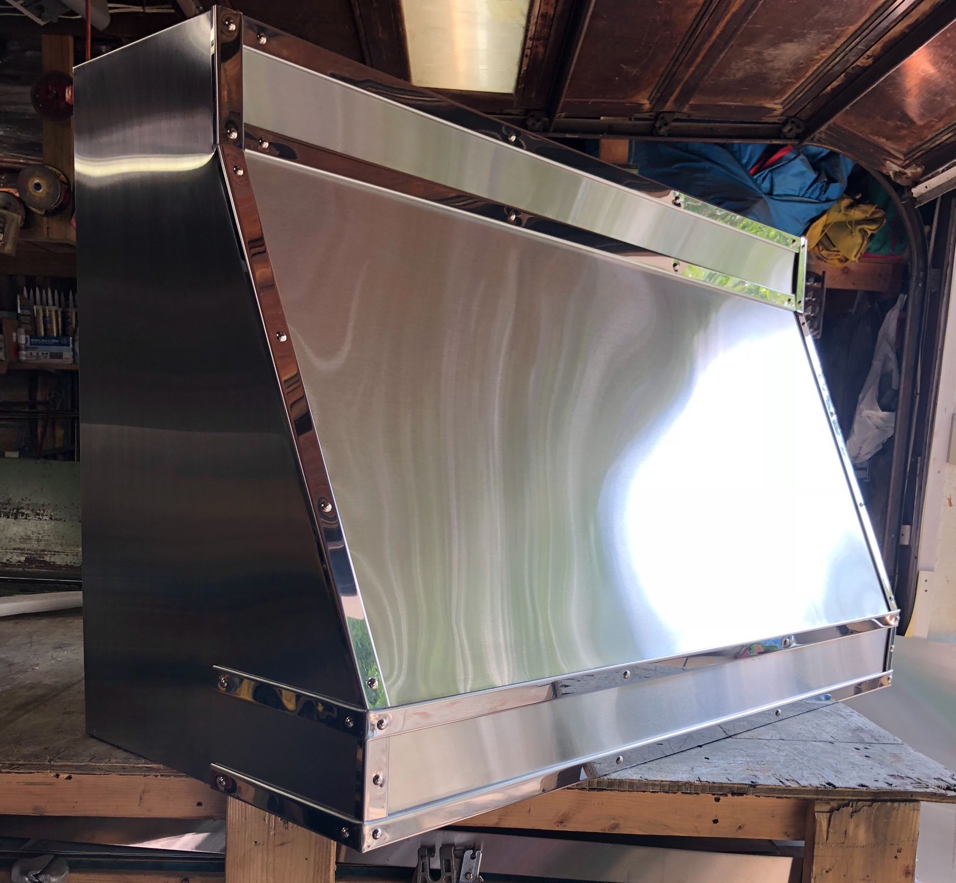A stainless steel box is sitting on a wooden table