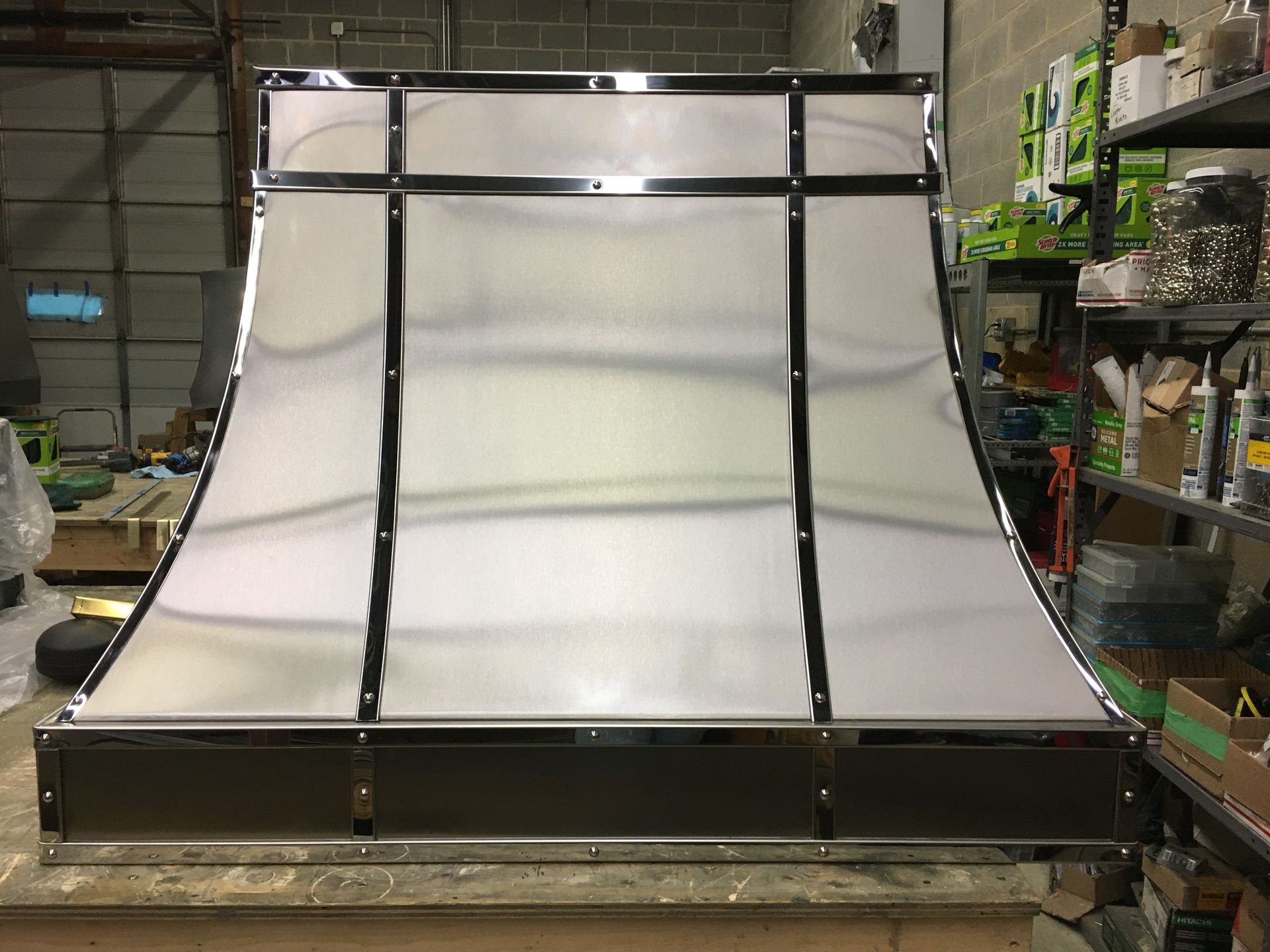 A stainless steel hood is sitting on top of a counter.