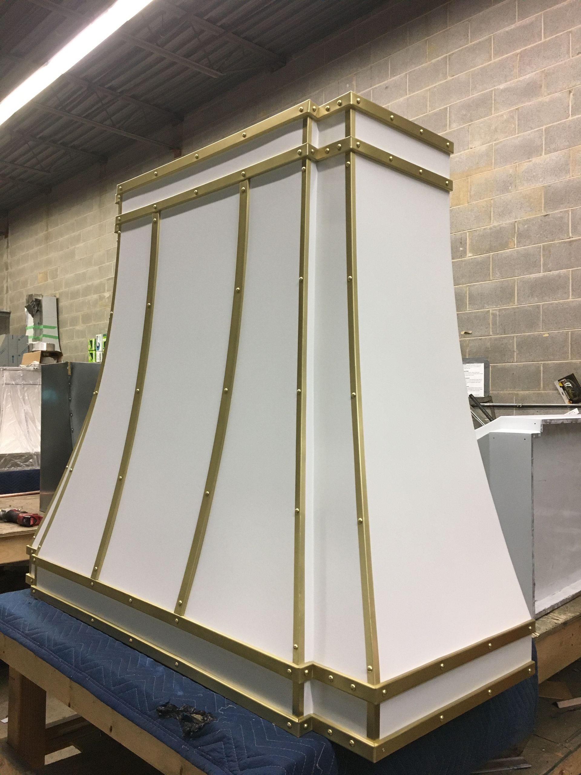A white hood with gold trim is sitting on a table