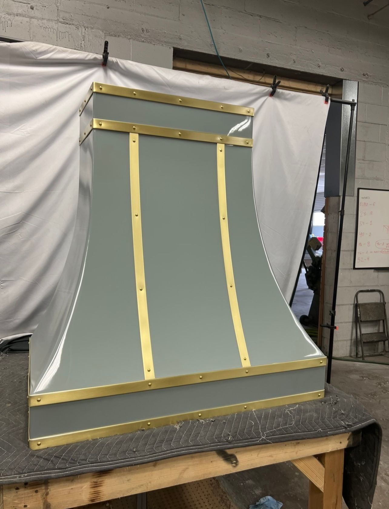 A gray and gold hood is sitting on a wooden table.