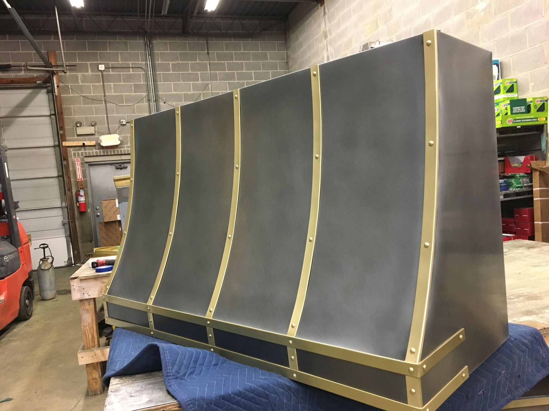 A black and gold hood is sitting on a table in a room.