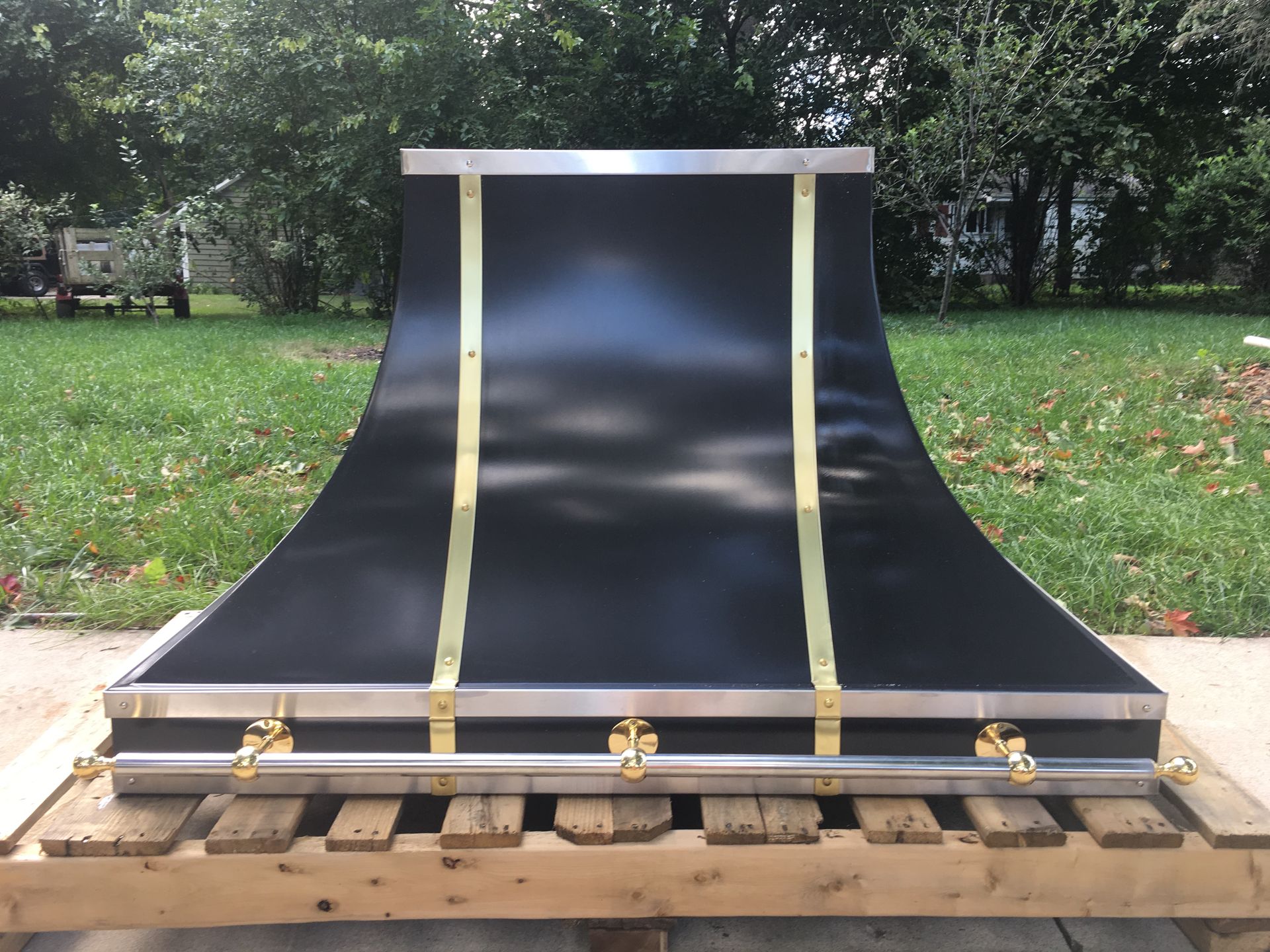 A black and gold hood is sitting on a wooden pallet