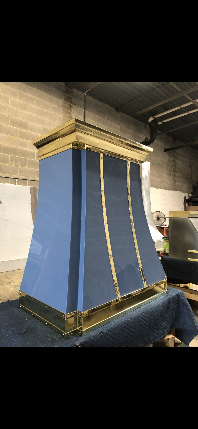 A blue and gold hood is sitting on top of a table.