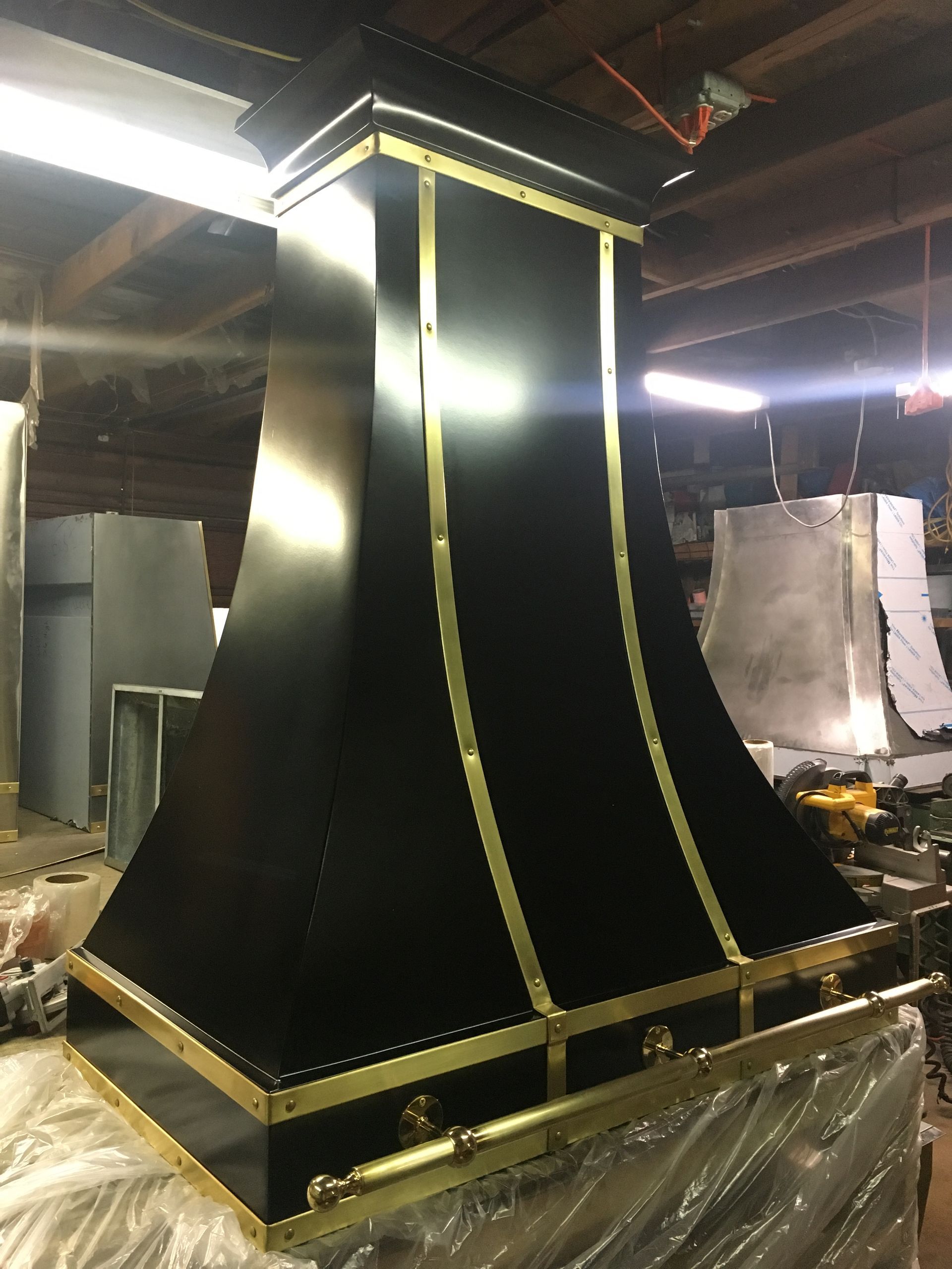 A black and gold hood is sitting in a warehouse.