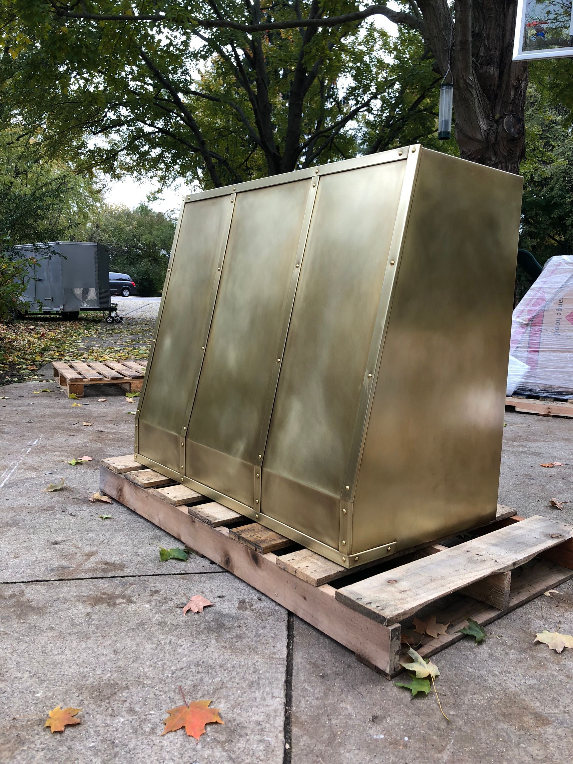 A large brass box is sitting on top of a wooden pallet.