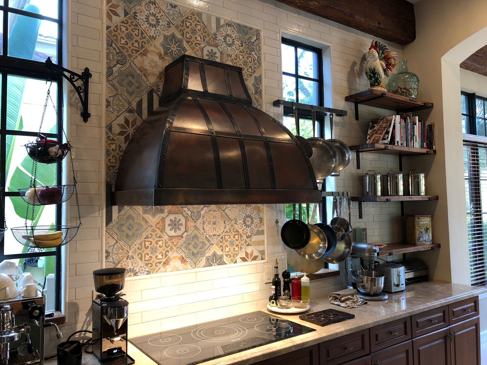 A kitchen with a copper hood and stove top oven.