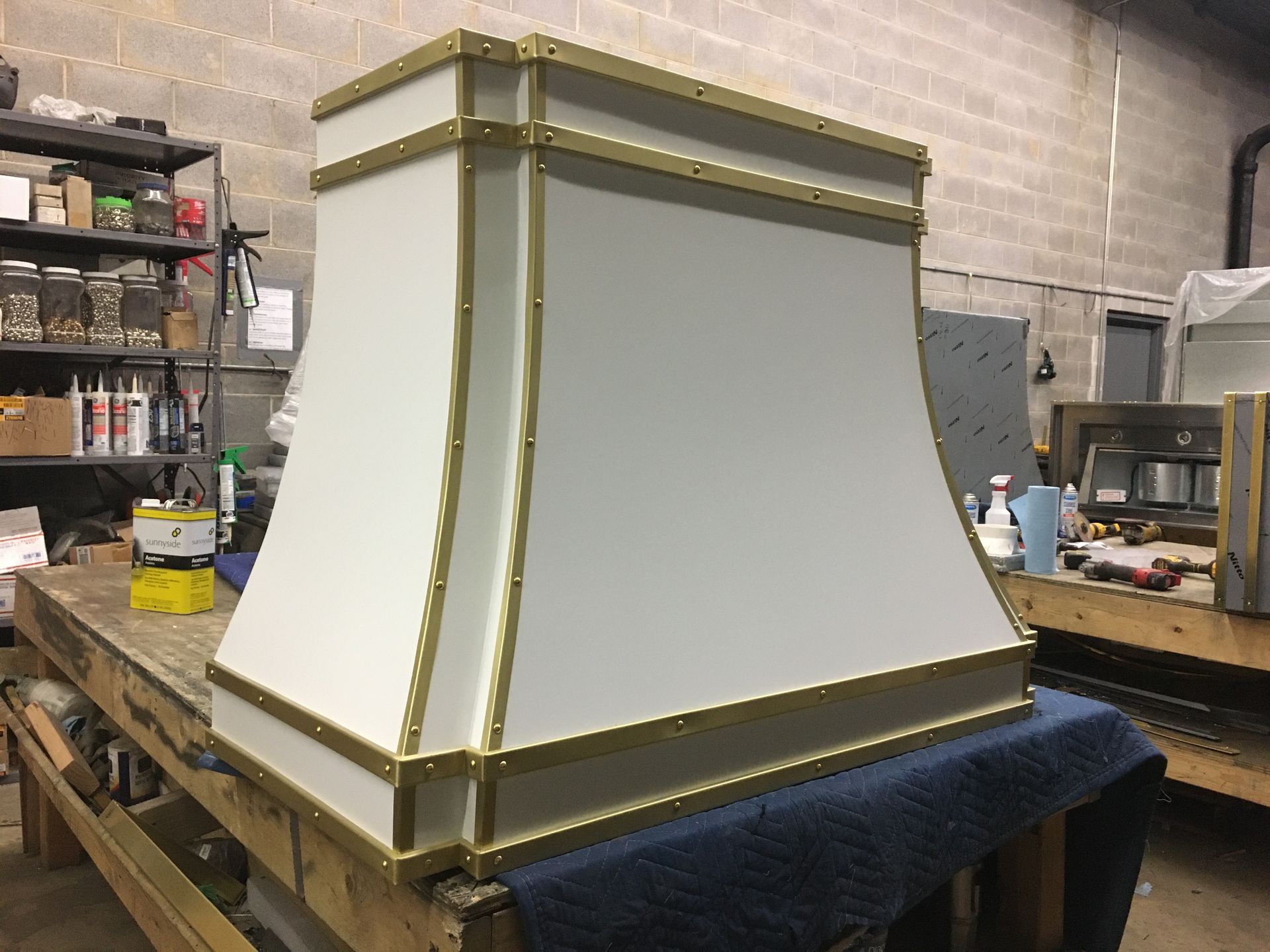 A white and gold hood is sitting on top of a wooden table.