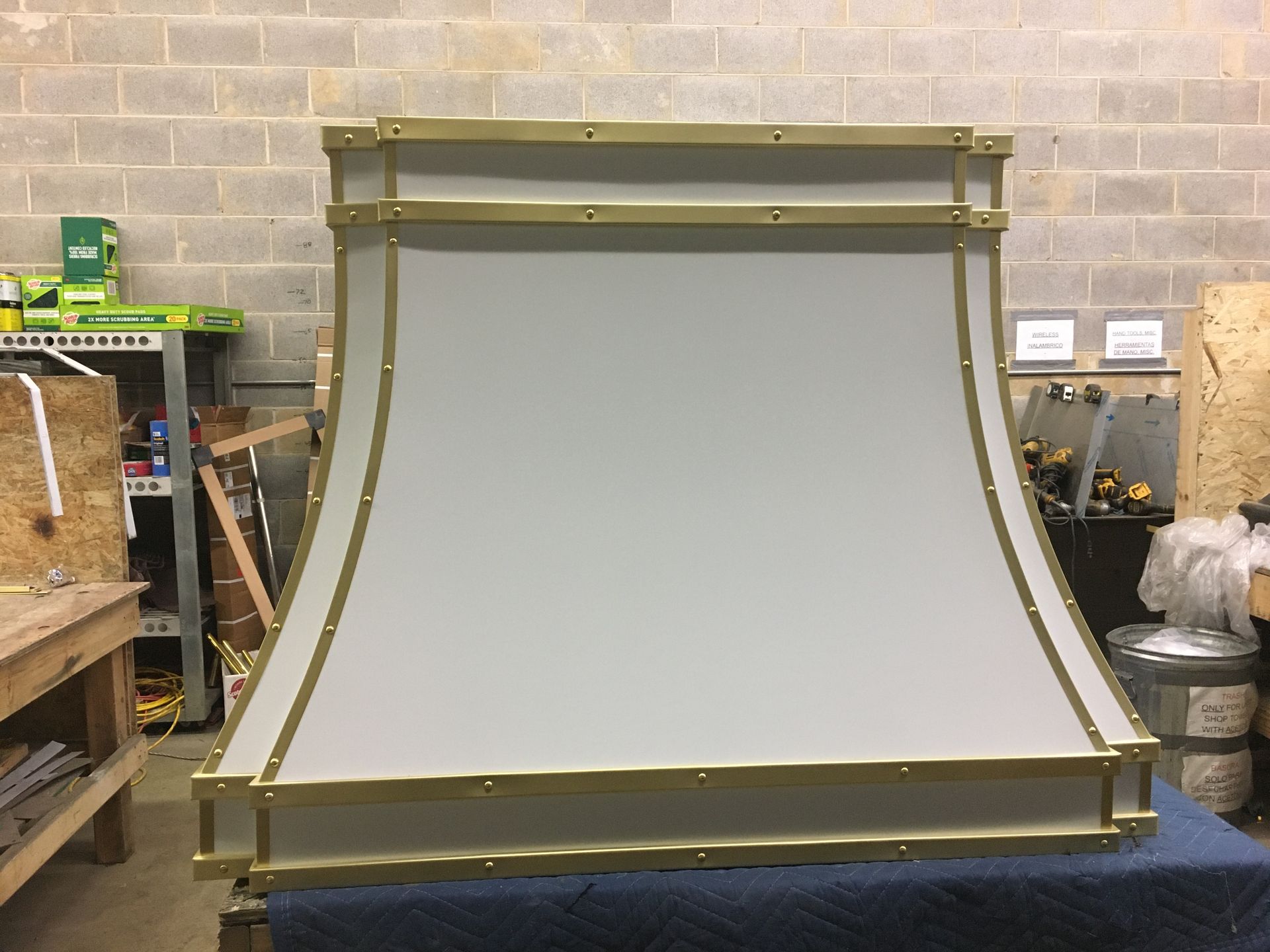 A white and gold hood is sitting on a table in a room.