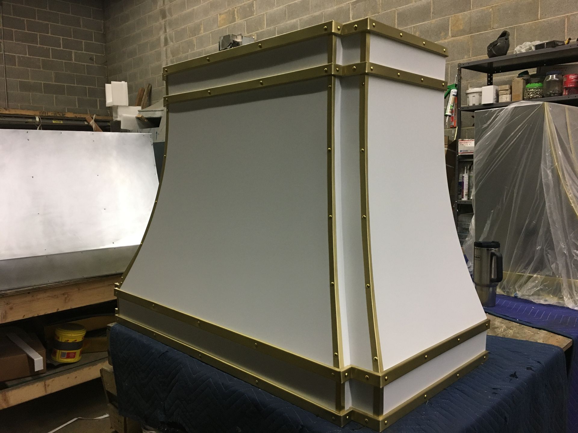 A white and gold hood is sitting on a table in a room.
