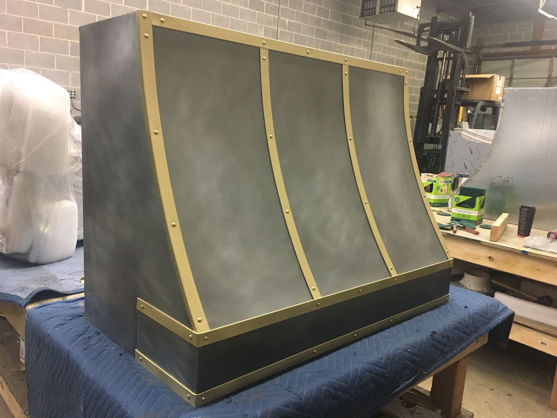 A large piece of metal is sitting on top of a blue blanket on a table.