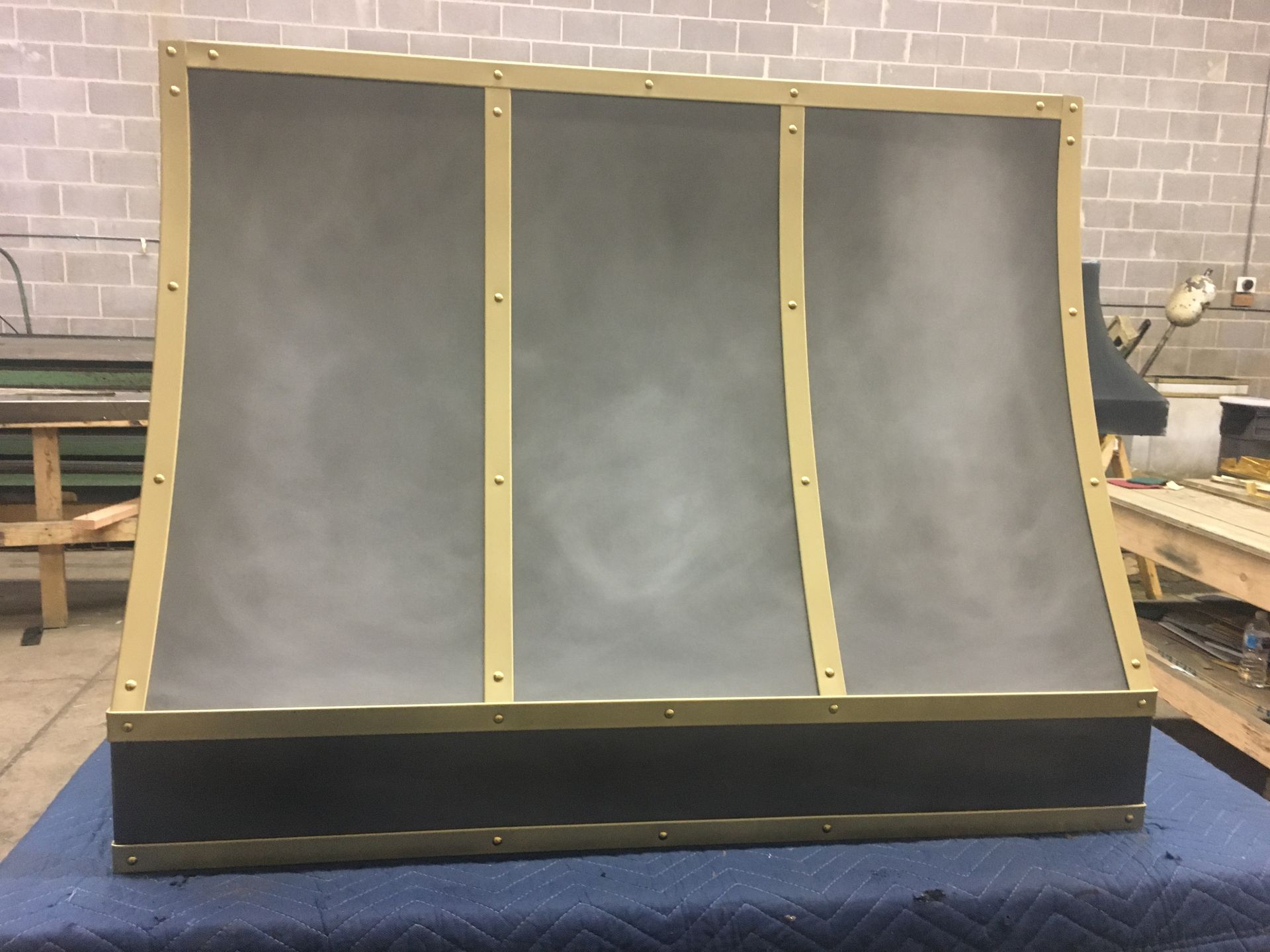 A piece of metal is sitting on a table in front of a brick wall