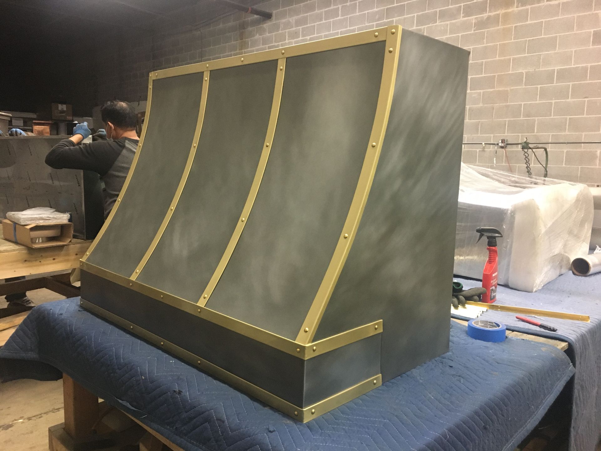 A gray and gold hood is sitting on top of a blue table.