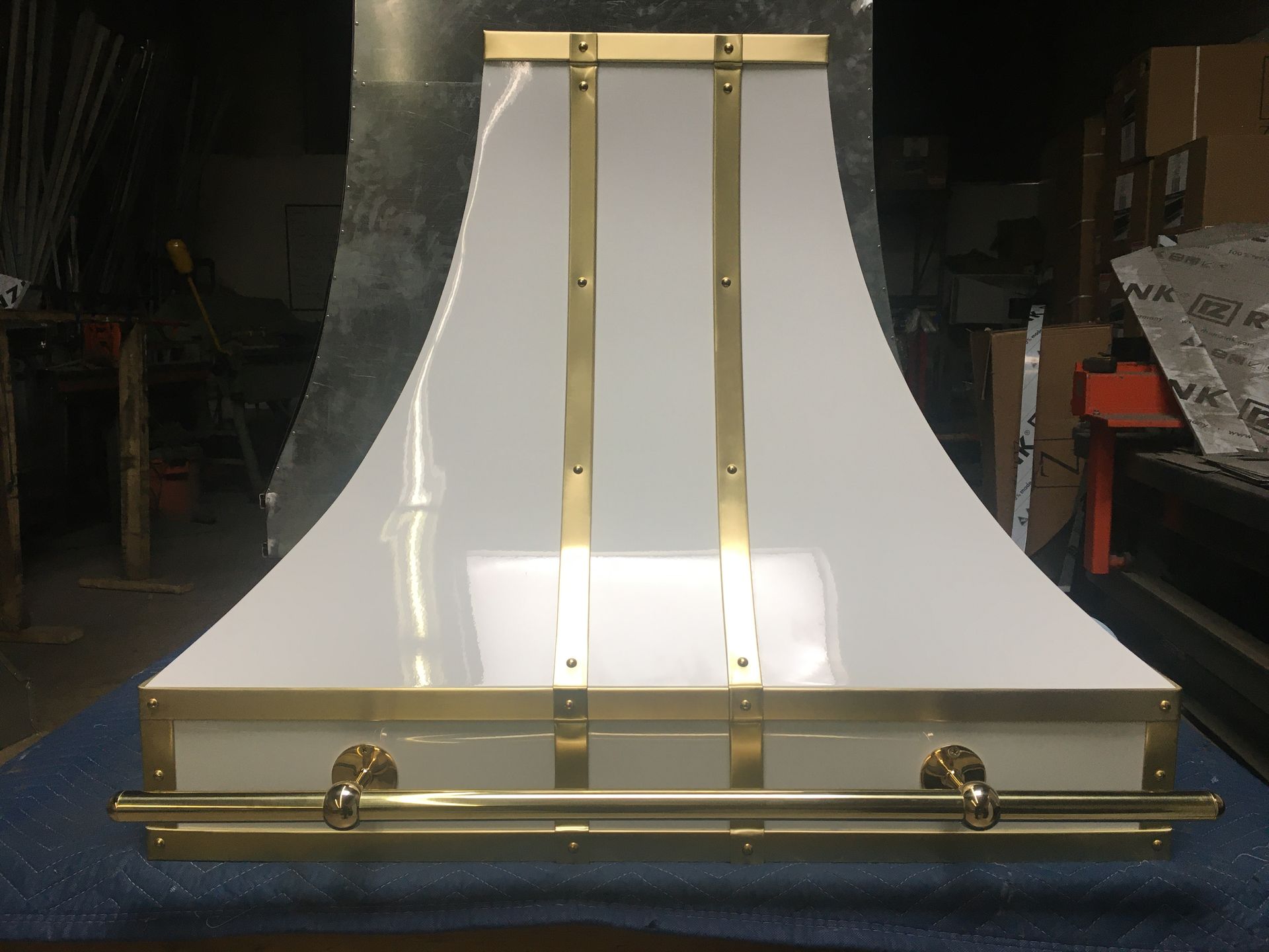 A white and gold hood is sitting on a blue table.