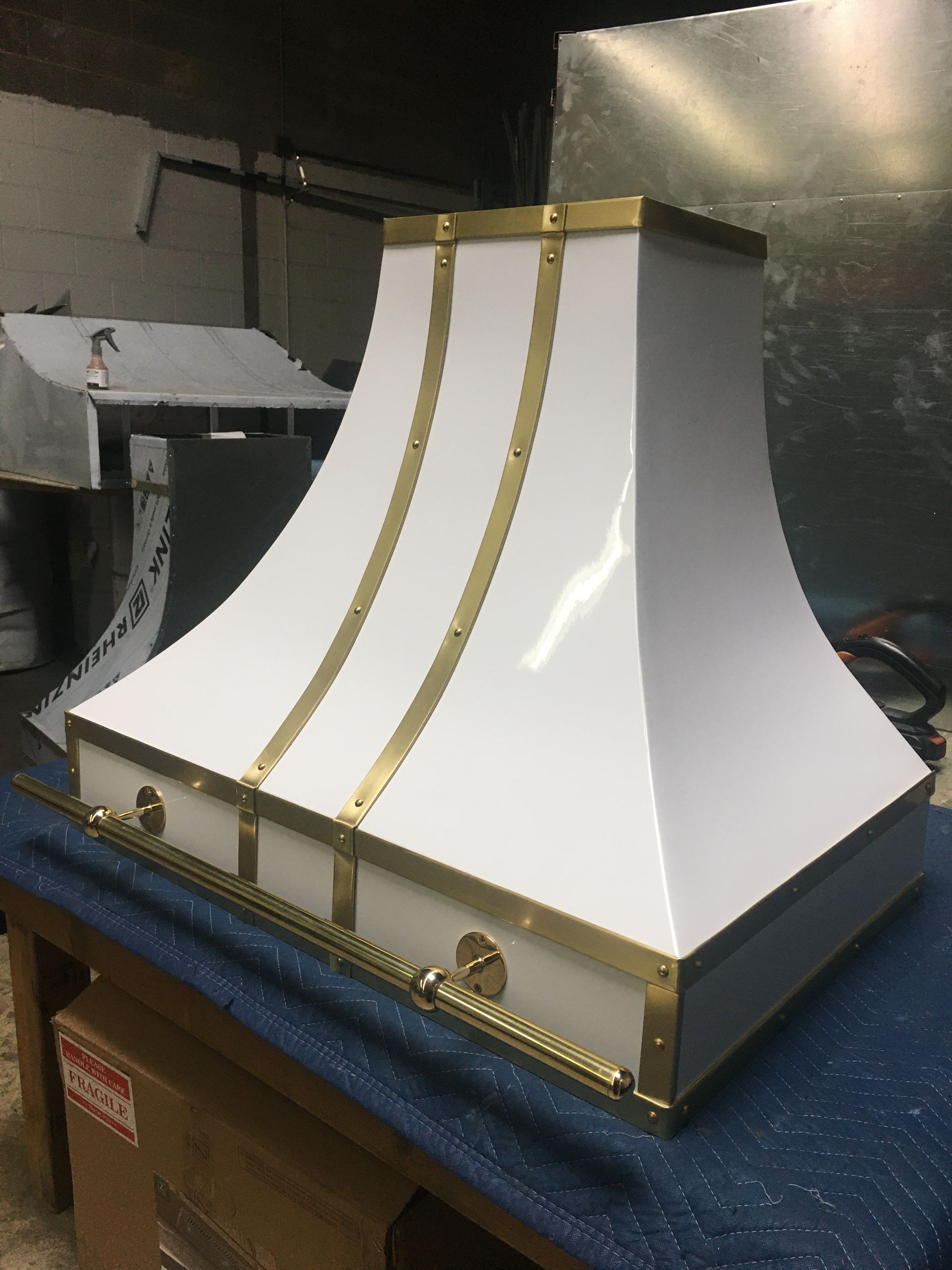 A white hood with gold trim sits on a table