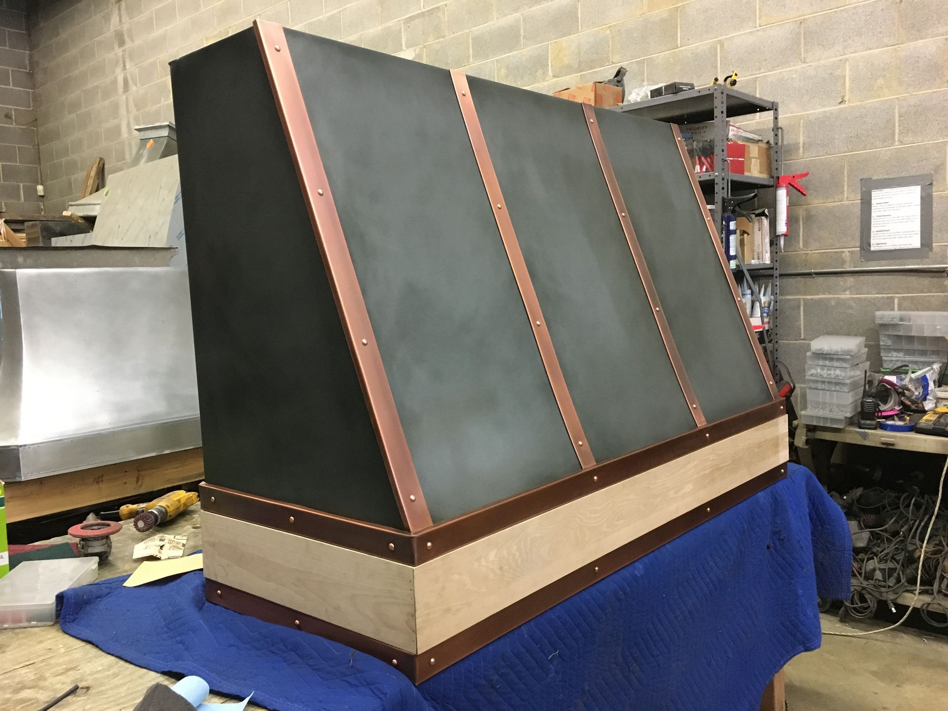 A black and copper hood is sitting on a blue table.