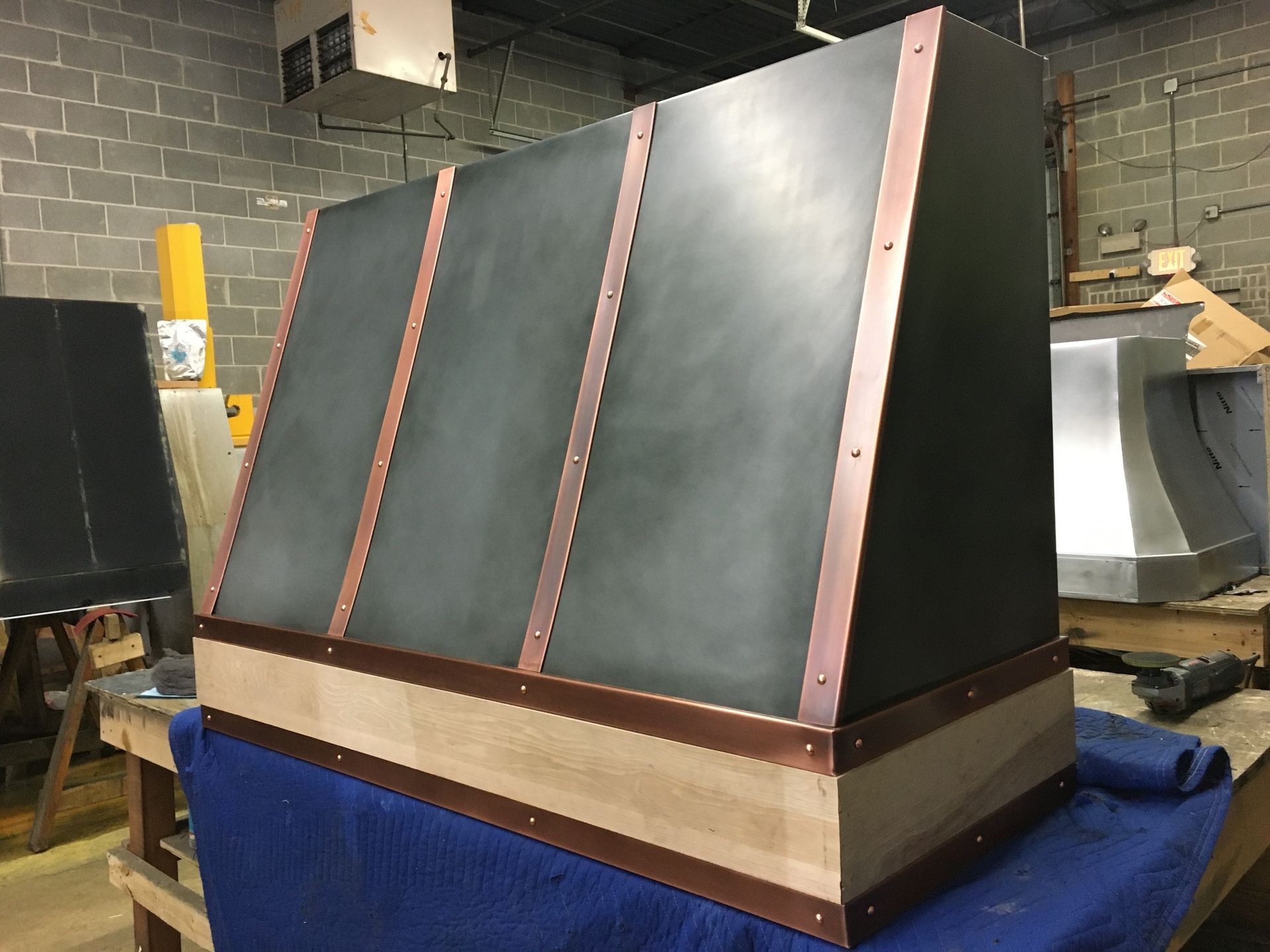 A black box with copper trim is sitting on a blue table.