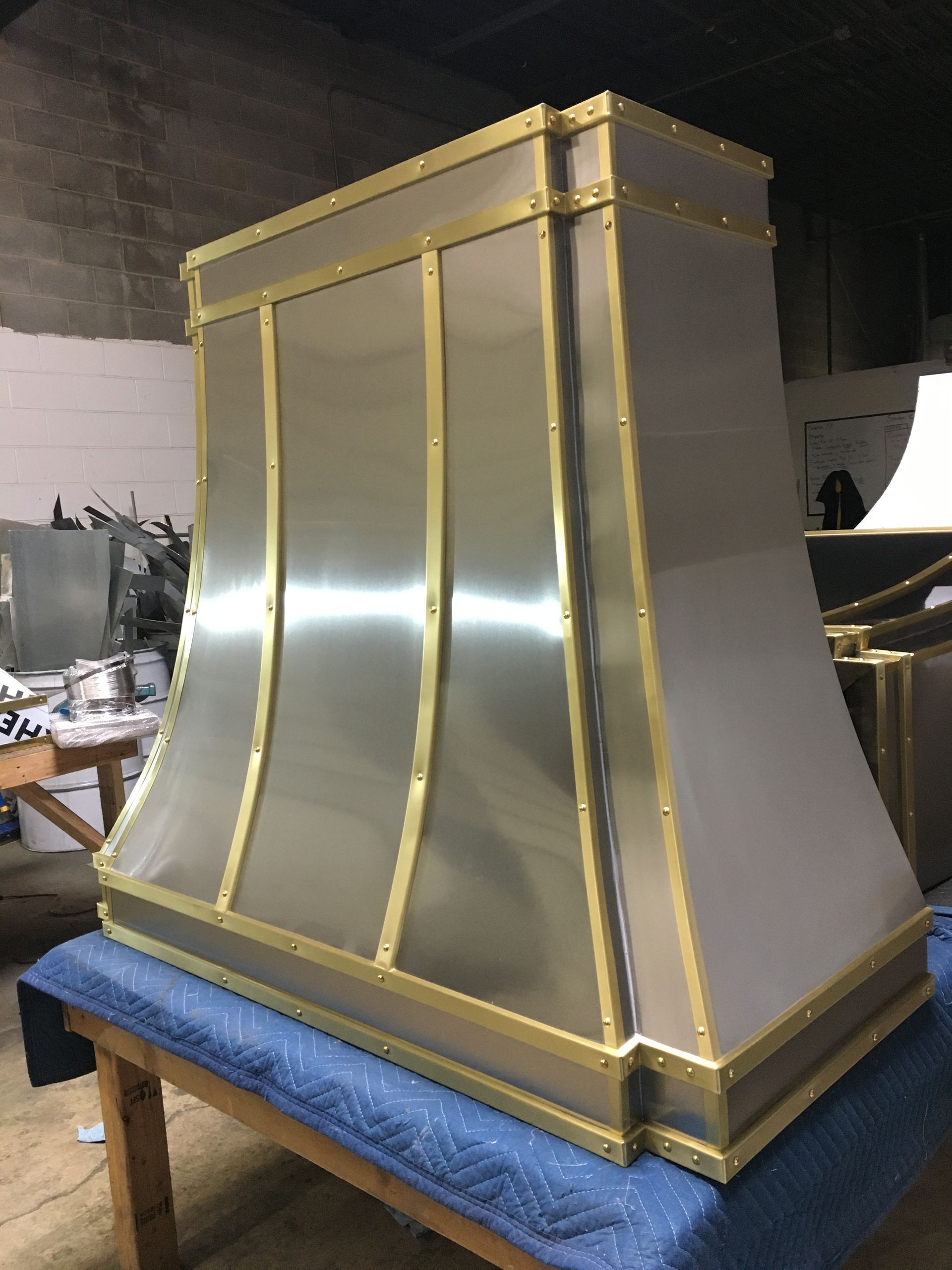 A stainless steel hood is sitting on top of a wooden table.