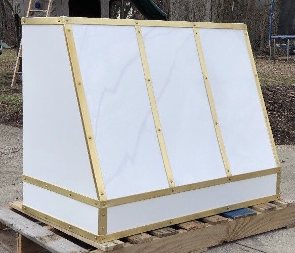 A white box with gold trim sits on a wooden pallet