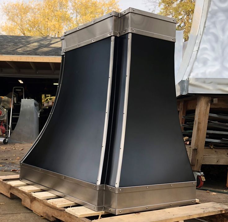 A black hood is sitting on top of a wooden pallet.