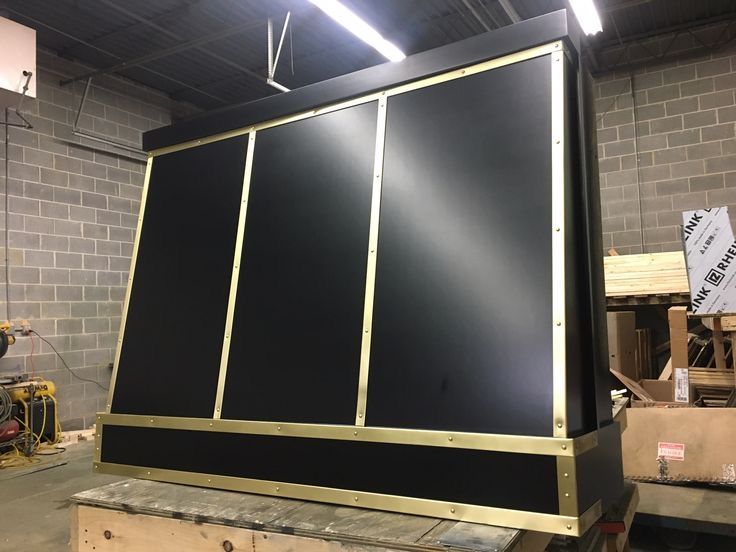 A black and gold item is sitting on top of a wooden table.