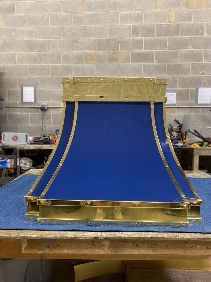 A blue and gold lamp shade is sitting on a wooden table.