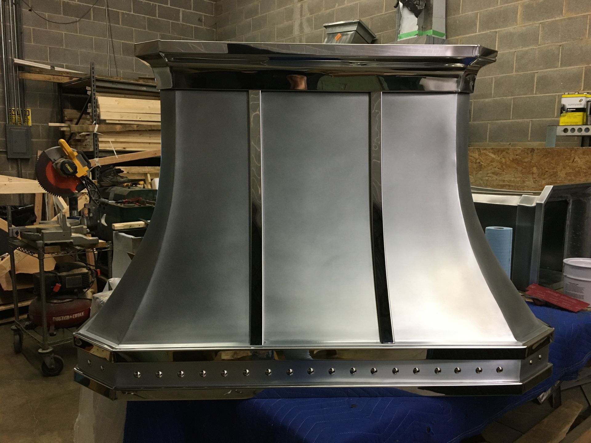 A stainless steel hood is sitting on a table in a room.