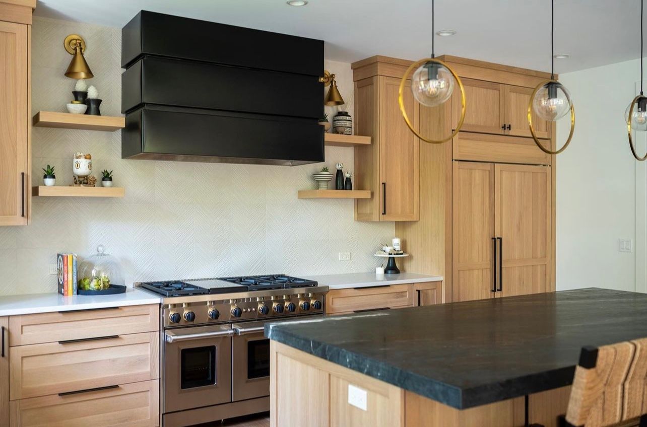 A kitchen with wooden cabinets , stainless steel appliances , and a large island.