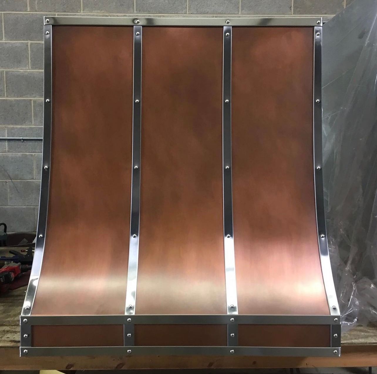 A copper hood is sitting on a wooden table