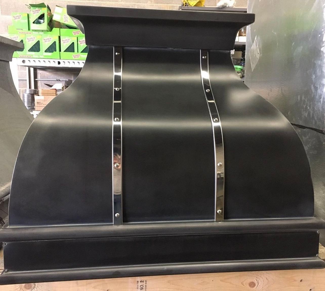 A black hood is sitting on top of a wooden table.