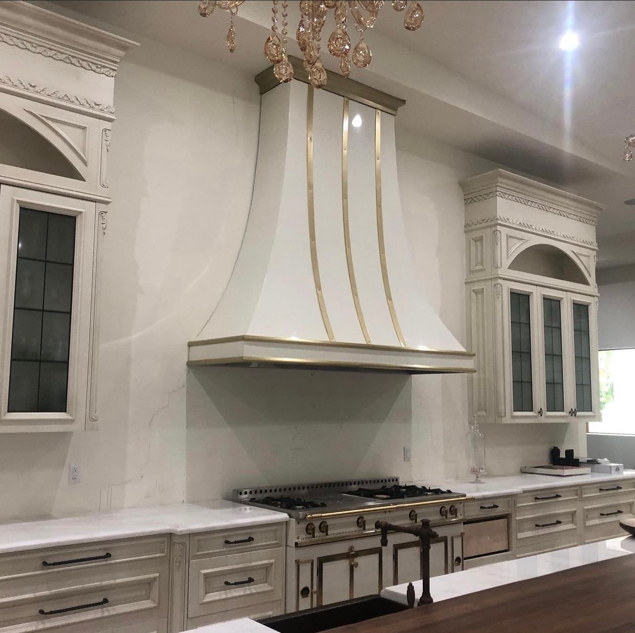 A kitchen with white cabinets and a stove top oven