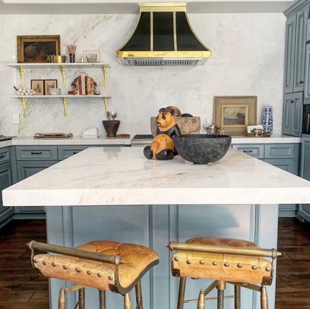 A kitchen with a large island and two bar stools