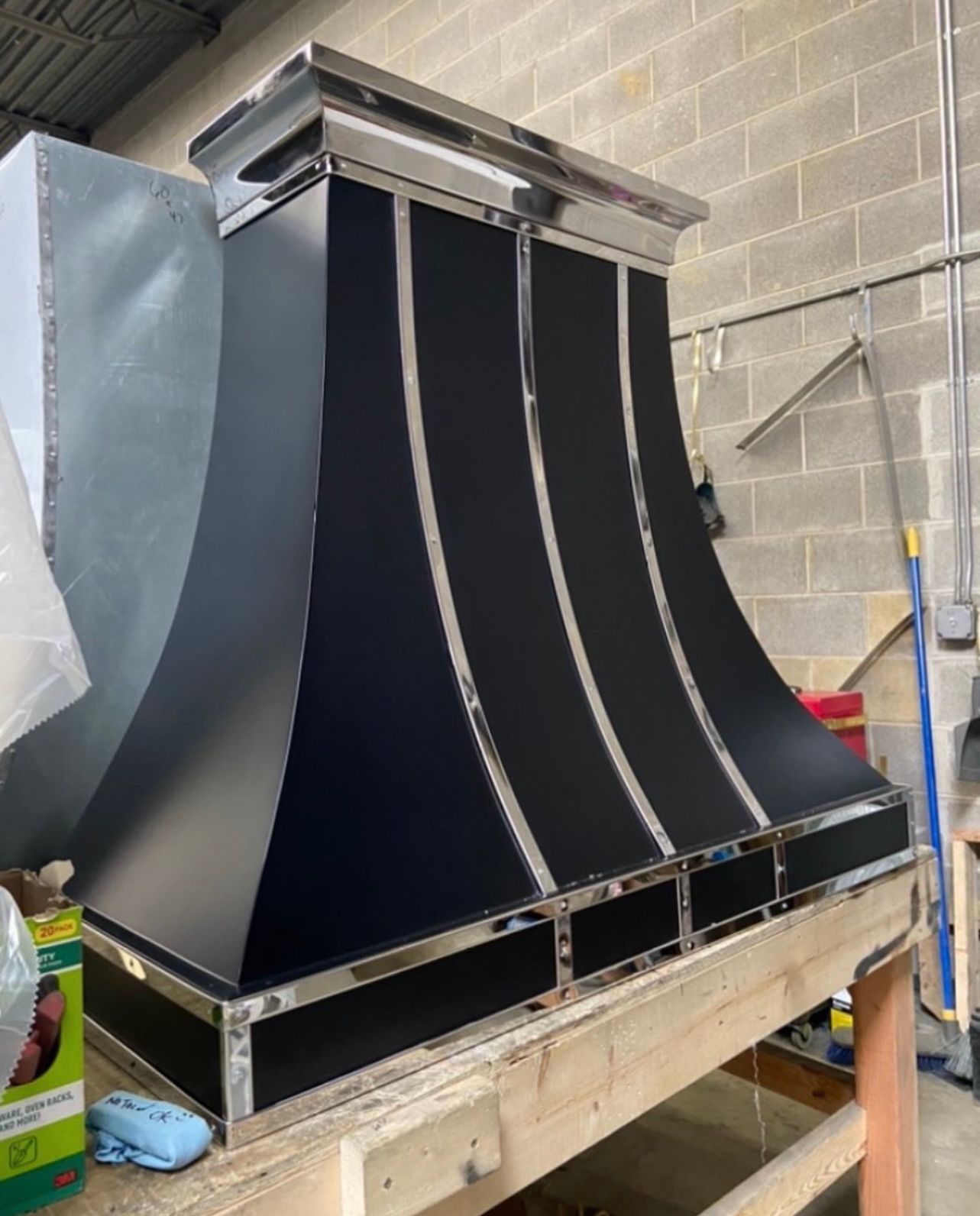 A black hood is sitting on top of a wooden table.