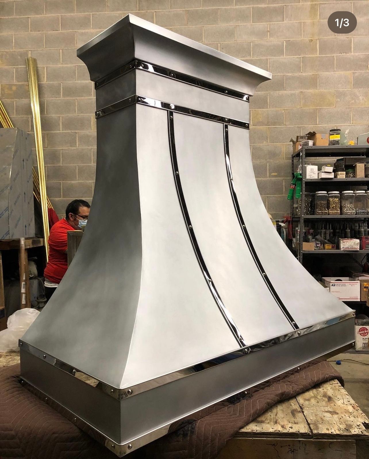 A stainless steel hood is sitting on a table in a room.