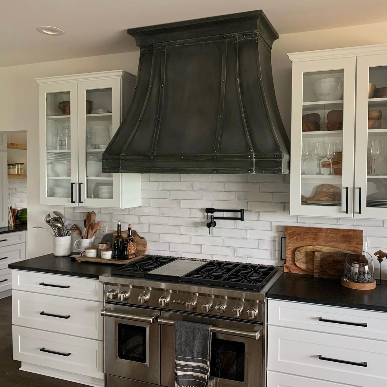 A kitchen with a stove , oven , and hood.