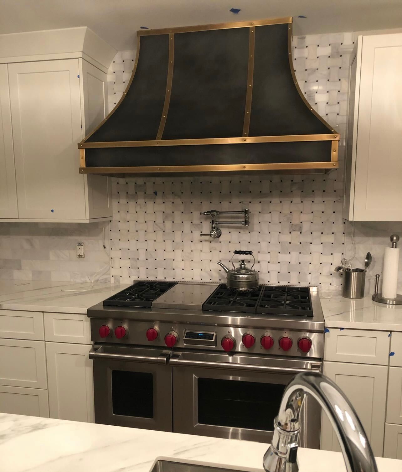 A kitchen with a stove top oven and a sink