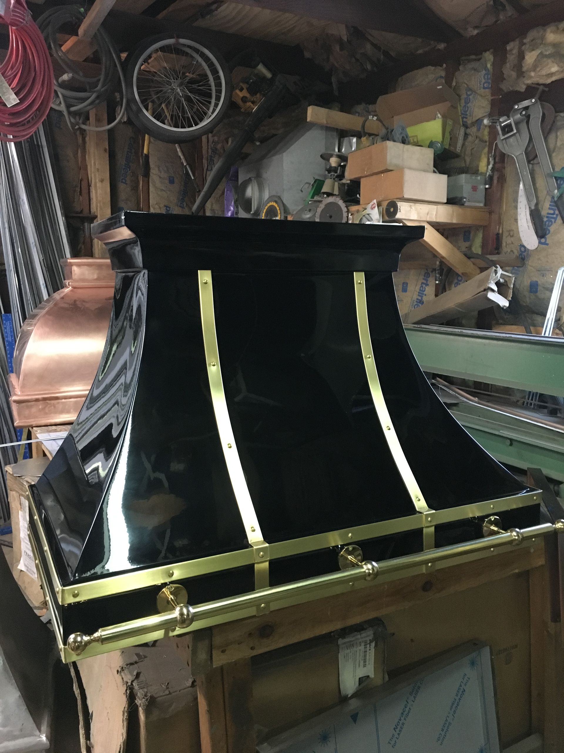 A black and gold hood is sitting on top of a wooden table.