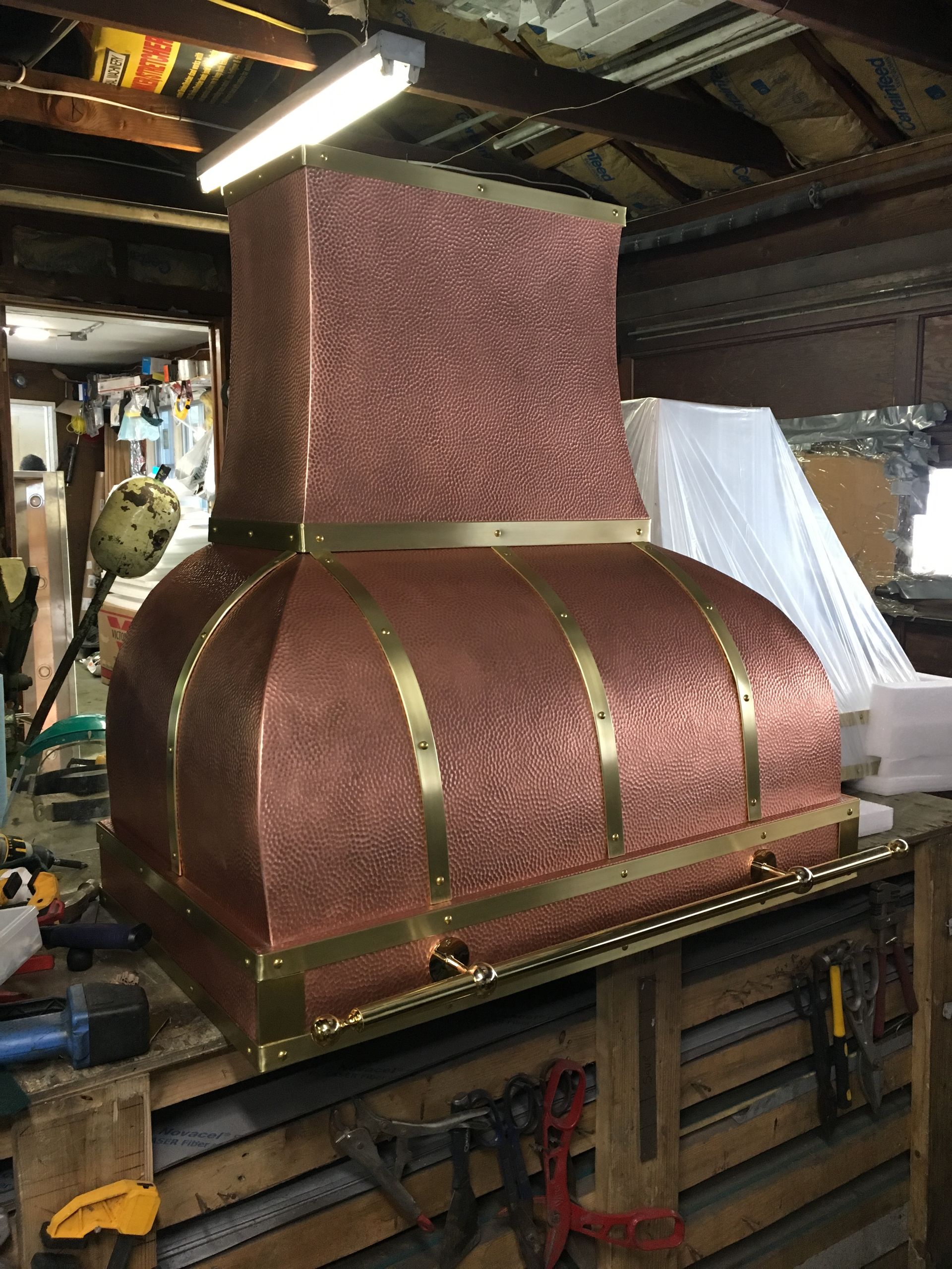 A copper hood is sitting on top of a wooden table.